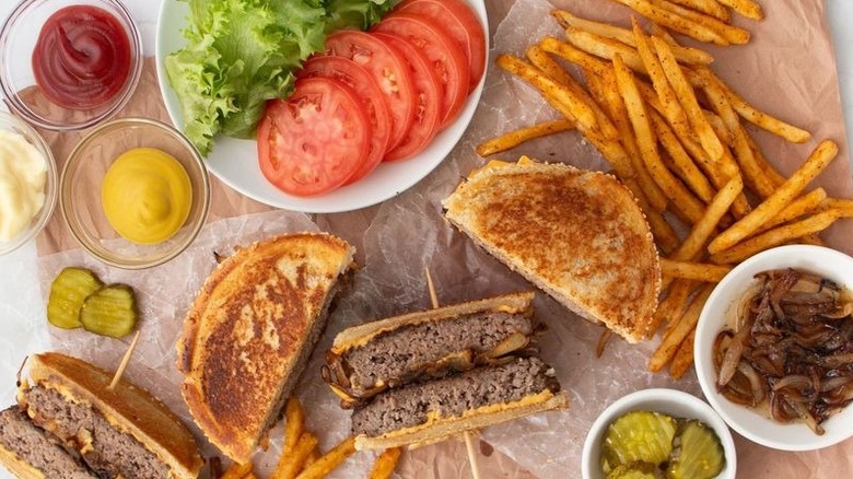 Patty melts with fries, various toppings, caramlized onions