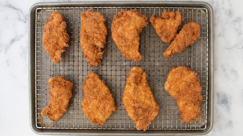 fried chicken draining on rack