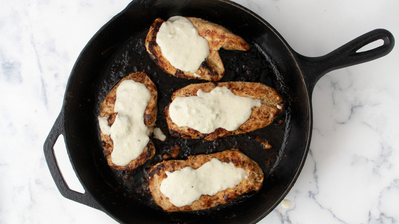 Chicken breasts with cheese sauce in skillet