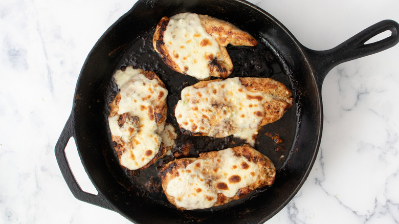 Chicken breasts with broiled cheese in skillet