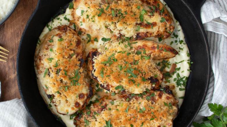 Parmesan crusted chicken in skillet with herbs