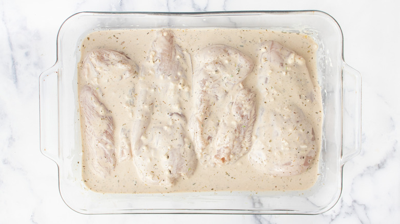 Raw chicken breasts submerged in creamy marinade