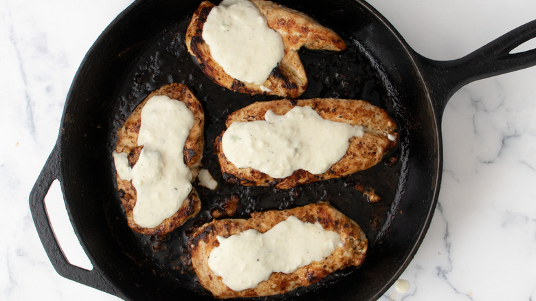 Chicken breasts with cheese sauce in skillet