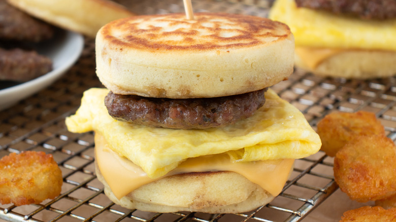 Breakfast sandwich made with thick pancakes, scrambled eggs, sausage patties, and American cheese