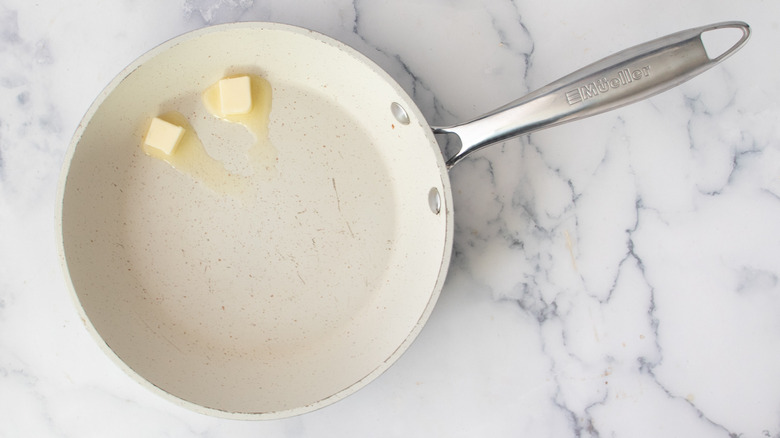 Melting butter in a white frying pan