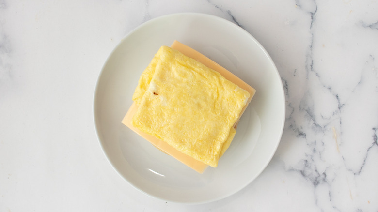 American cheese and cooked egg on a white plate