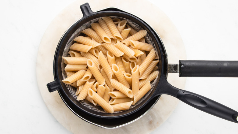 pasta draining over saucepan