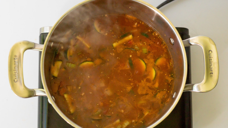 extra broth in minestrone soup pot with vegetables