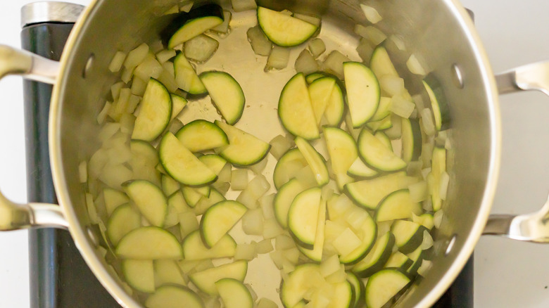 chopped onions, zucchini, and celery cooking in pot