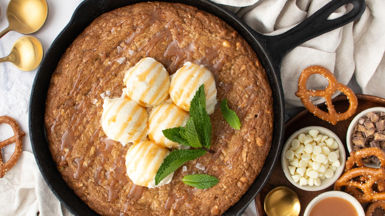 Skillet cookie topped with vanilla ice cream and caramel sauce