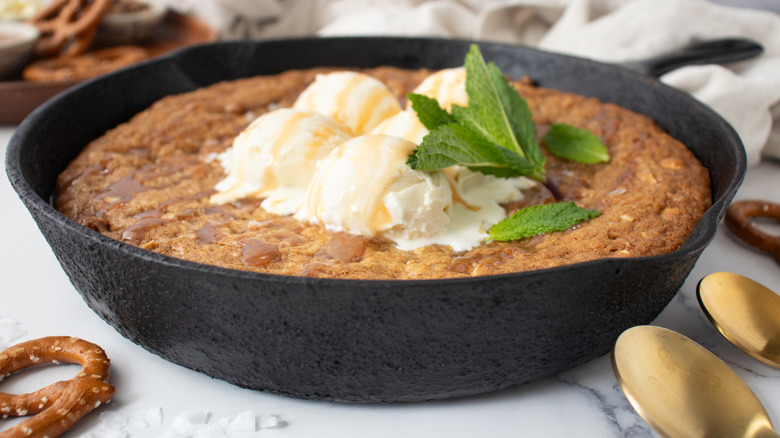 Skillet cookie topped with vanilla ice cream and caramel sauce