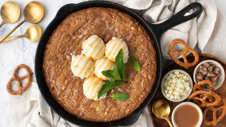 Skillet cookie topped with vanilla ice cream and caramel sauce