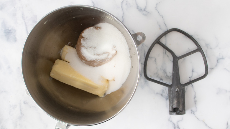 Butter, brown sugar, and white sugar in a metal bowl