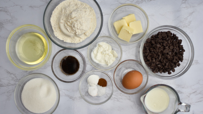 different kinds of ingredients placed in small bowls and a measuring cup