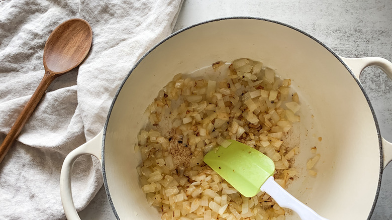 Cooked garlic and onions in pot with spatula