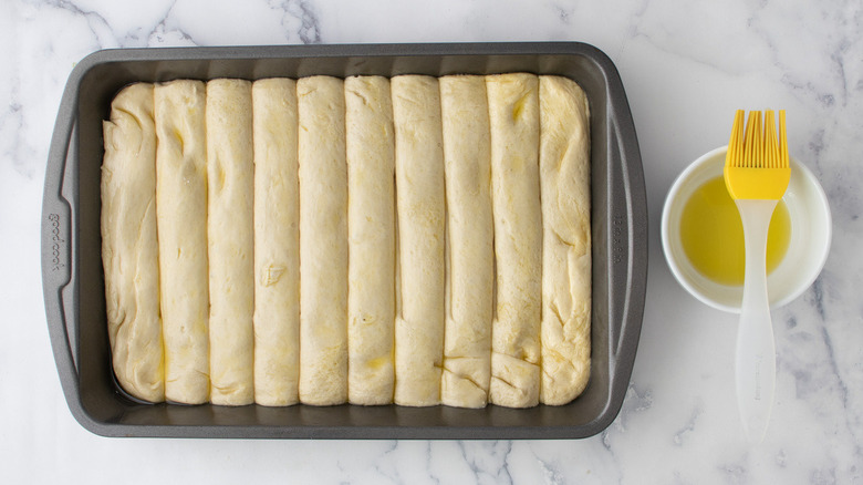 unbaked breadsticks brushed with oil
