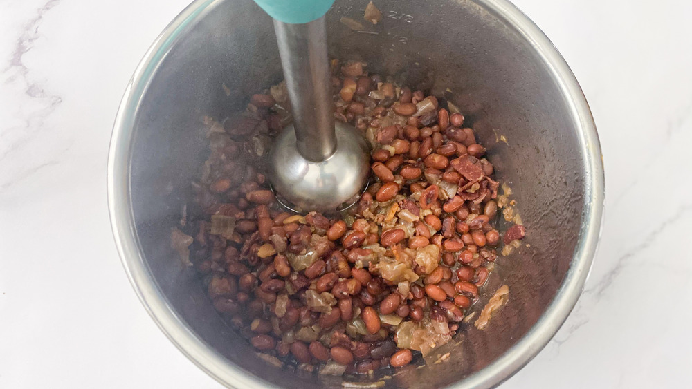 immersion blender mashing beans in Instant Pot for copycat Popeyes red beans and rice