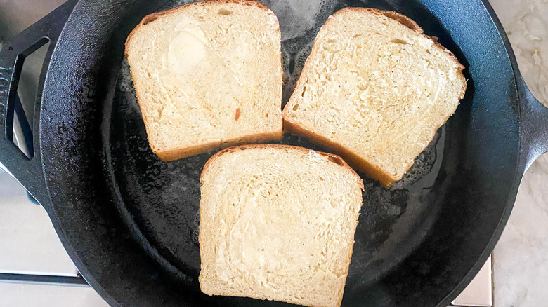 Buttered bread in iron skillet