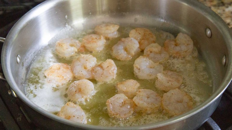 shrimp cooking in metal skillet