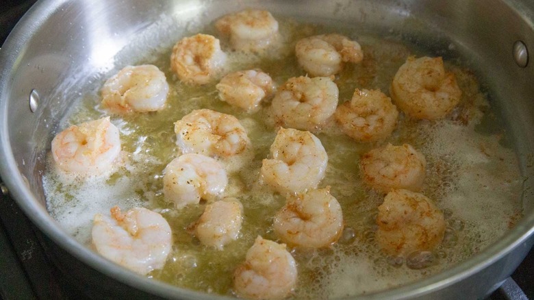 shrimp cooking in metal skillet