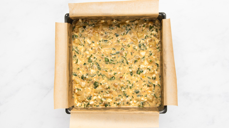 Egg, cheese, chive, and potato mixture in lined baking pan