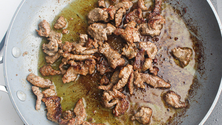 meat cooking in frying pan