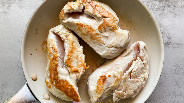 Chicken breasts cooking in a pan