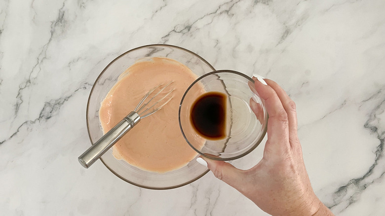 hand pouring Worcestershire sauce