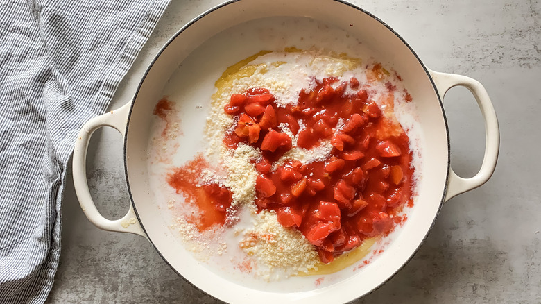 tomatoes and cheese added to pot