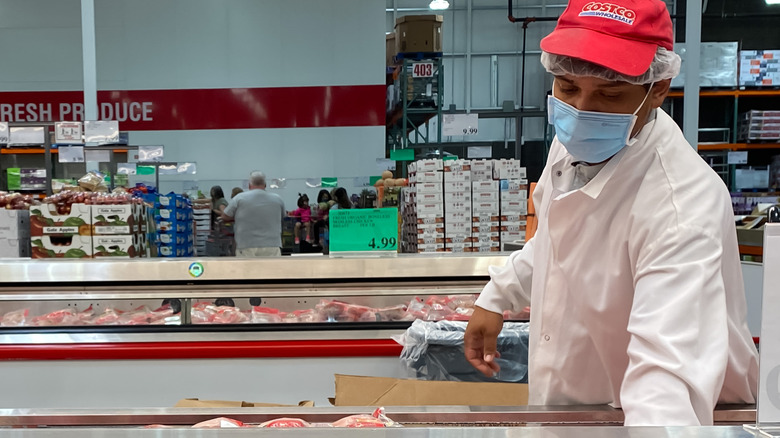 Costco employee stocking meat 