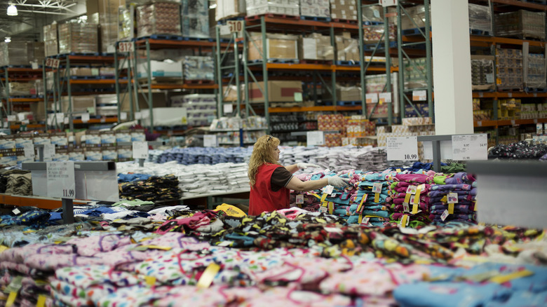 Woman folds clothes at Costco