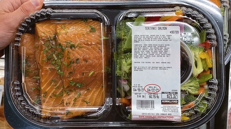 Closeup of plastic container with salmon and vegetables