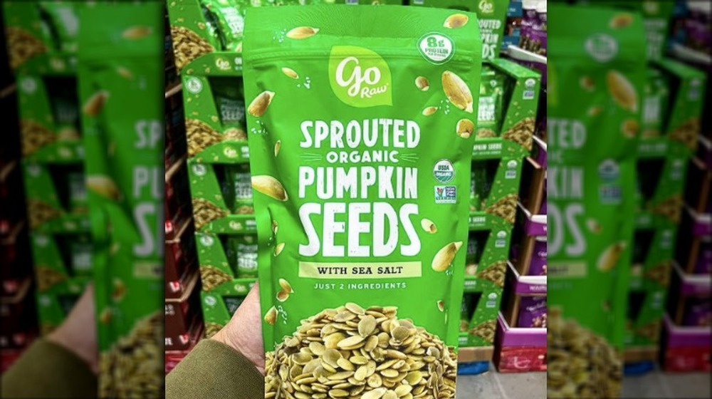 person holding bag of sprouted pumpkin seeds