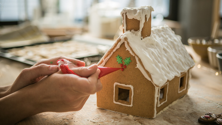 Person decorating gingerbread house