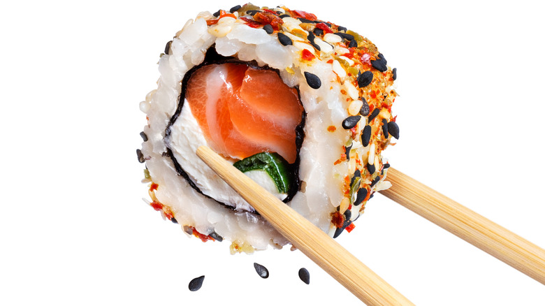 sushi roll in chopsticks