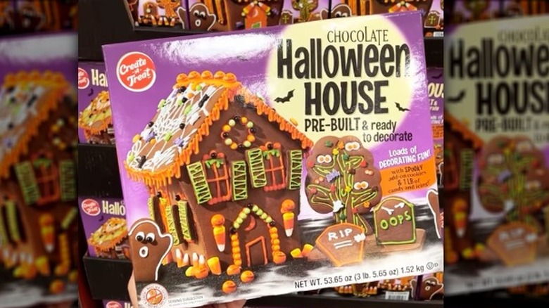 a person holding up a halloween gingerbread house