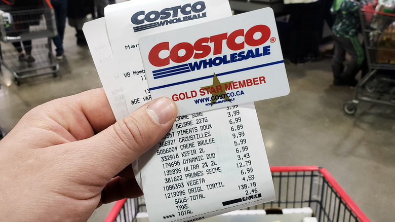 Hand holding Costco receipt