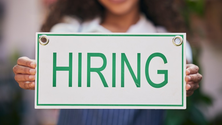 Woman holding hiring sign