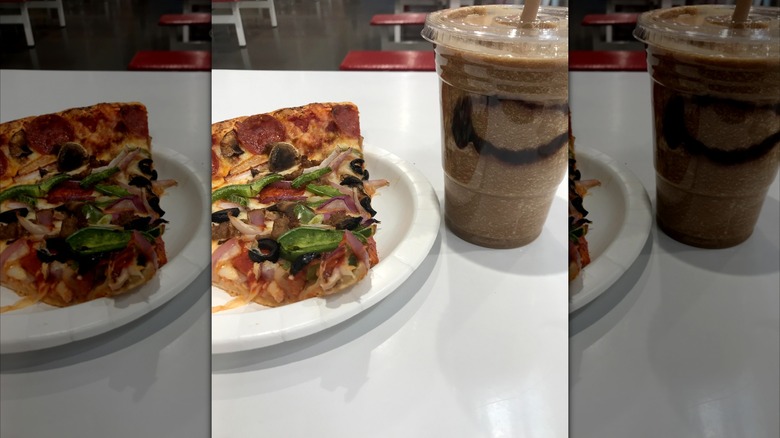 Slice of Costco's combo pizza next to drink