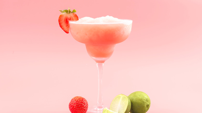 A glass of strawberry margarita and mixed fruit
