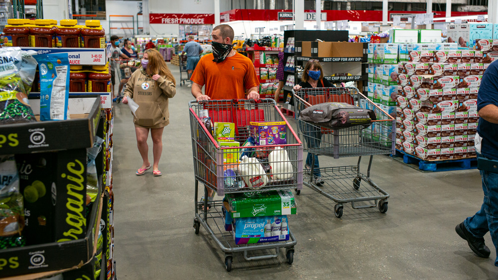 Shoppers in masks strolling through a Costco. Our dystopian nightmares made banal by reality. 