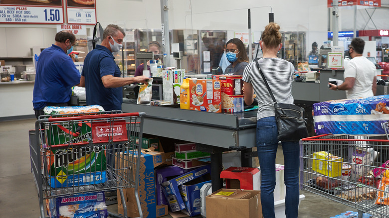 Customers wear masks at checkout  