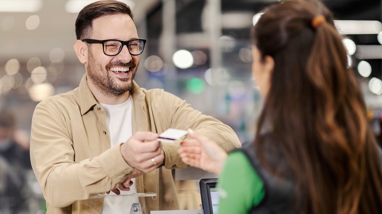 Smiling man paying for groceries