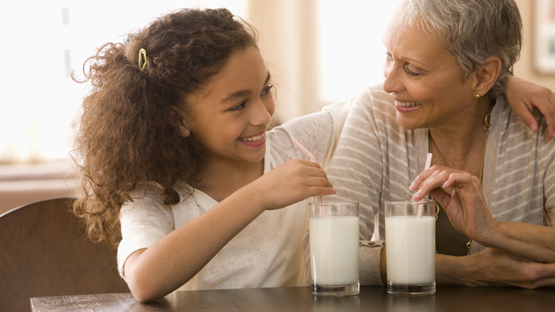 grandmother and granddaughter drinking milk