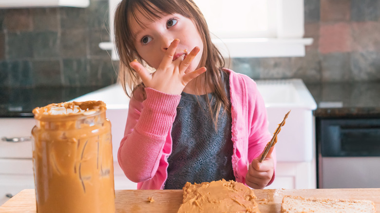 little girl eating peanut butter