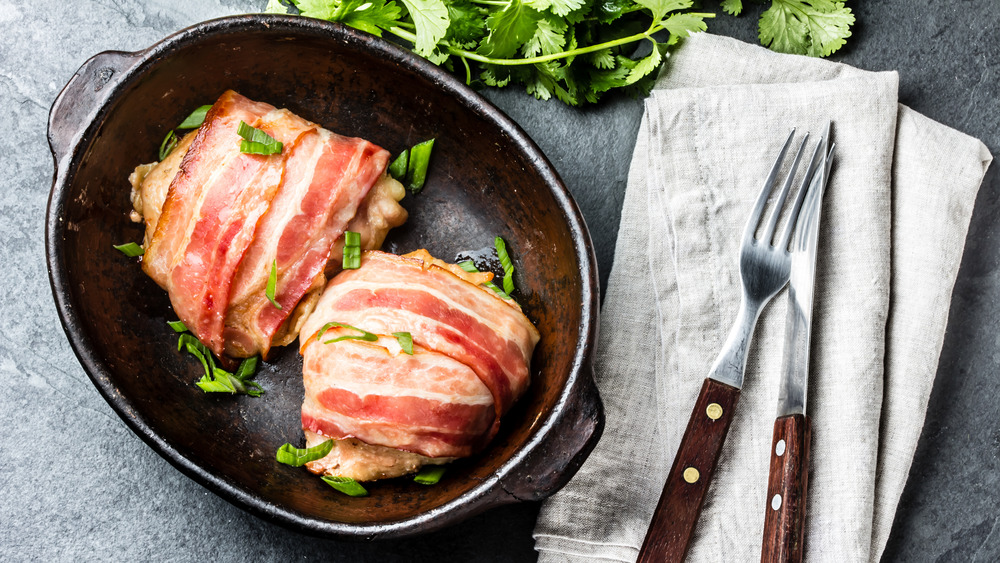 Bacon wrapped chicken on a black plate