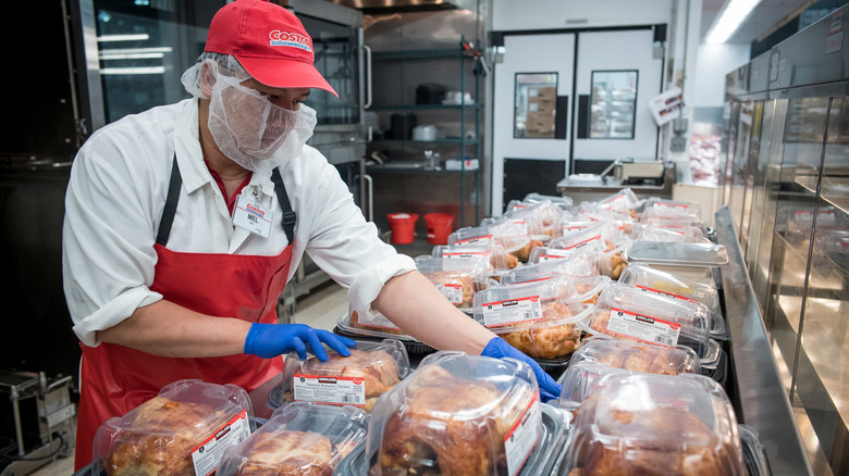 Costco employee displays rotisserie chickens