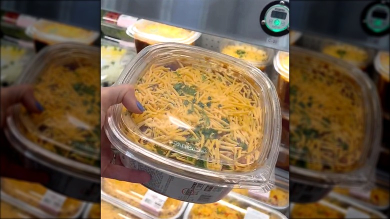 shopper grabbing tub of Costco chili