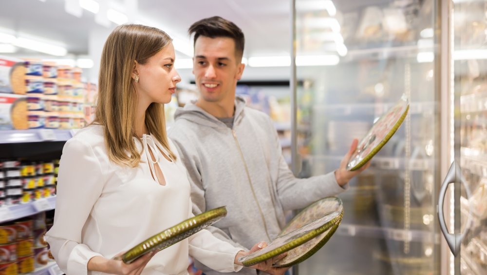 Man and woman selecting a frozen pizza