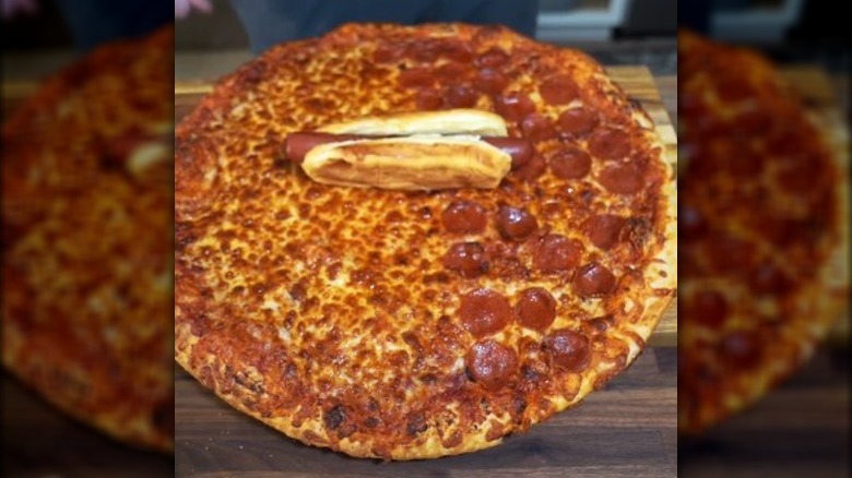 A Costco hot dog on top of a Costco pizza.